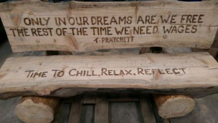 Larch bench with quotation written with router and scorched darkened.